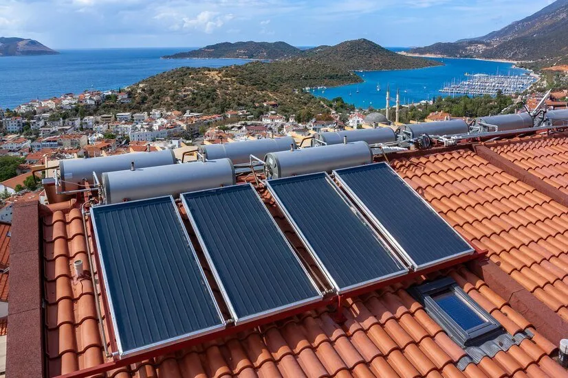 Chauffe-eau solaires installés sur toit de tuiles avec vue sur la mer